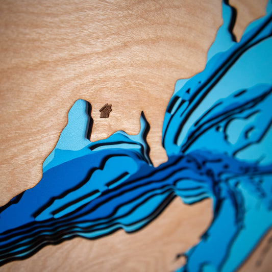 A close-up of a handcrafted wooden map featuring a custom heart engraving on the coastline, showcasing personalised design details.