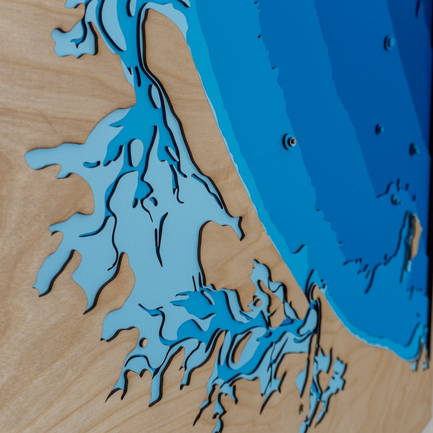 Detailed close-up of the Bay of Plenty wooden map, highlighting the precision-cut layers and intricate detailing of the area's topography and surrounding seas.