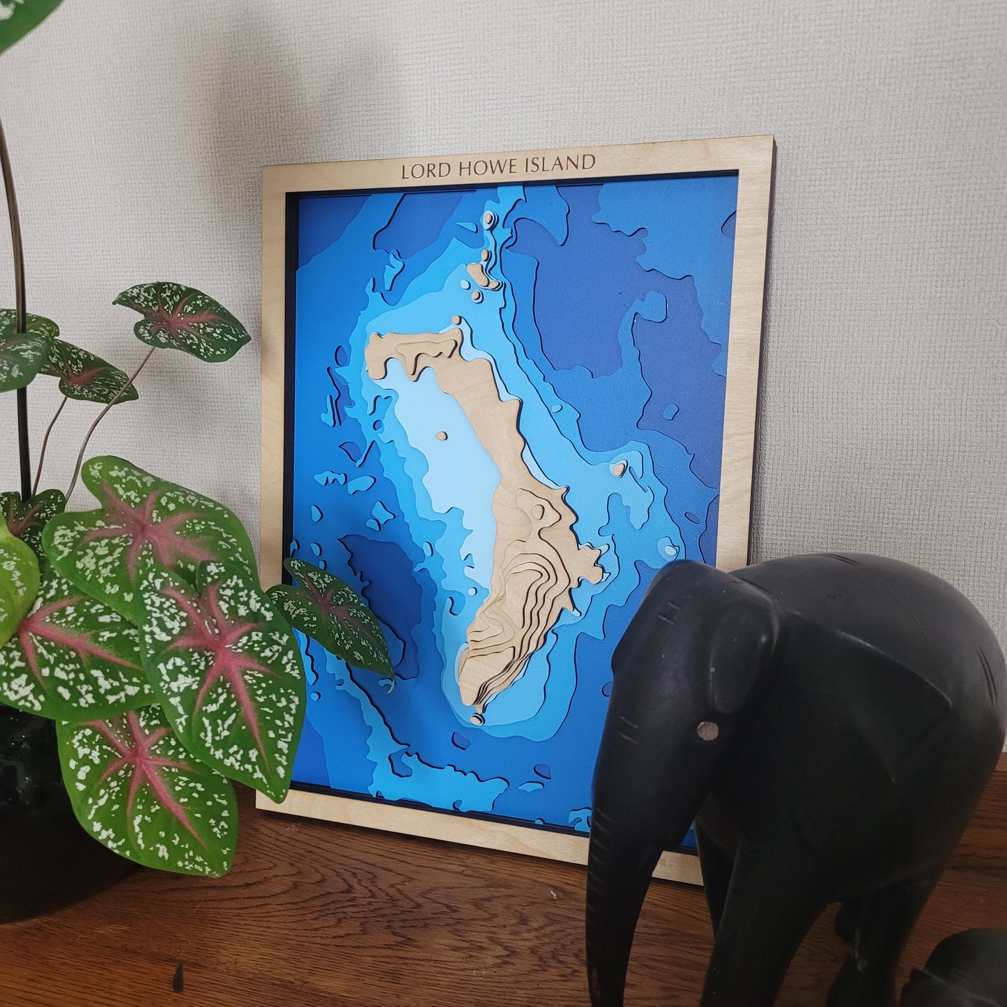 Custom small wooden depth map by Tide's Out Maps, featuring laser-cut European Birch layers up to 40x40cm, showcasing personalized coastal or lake designs