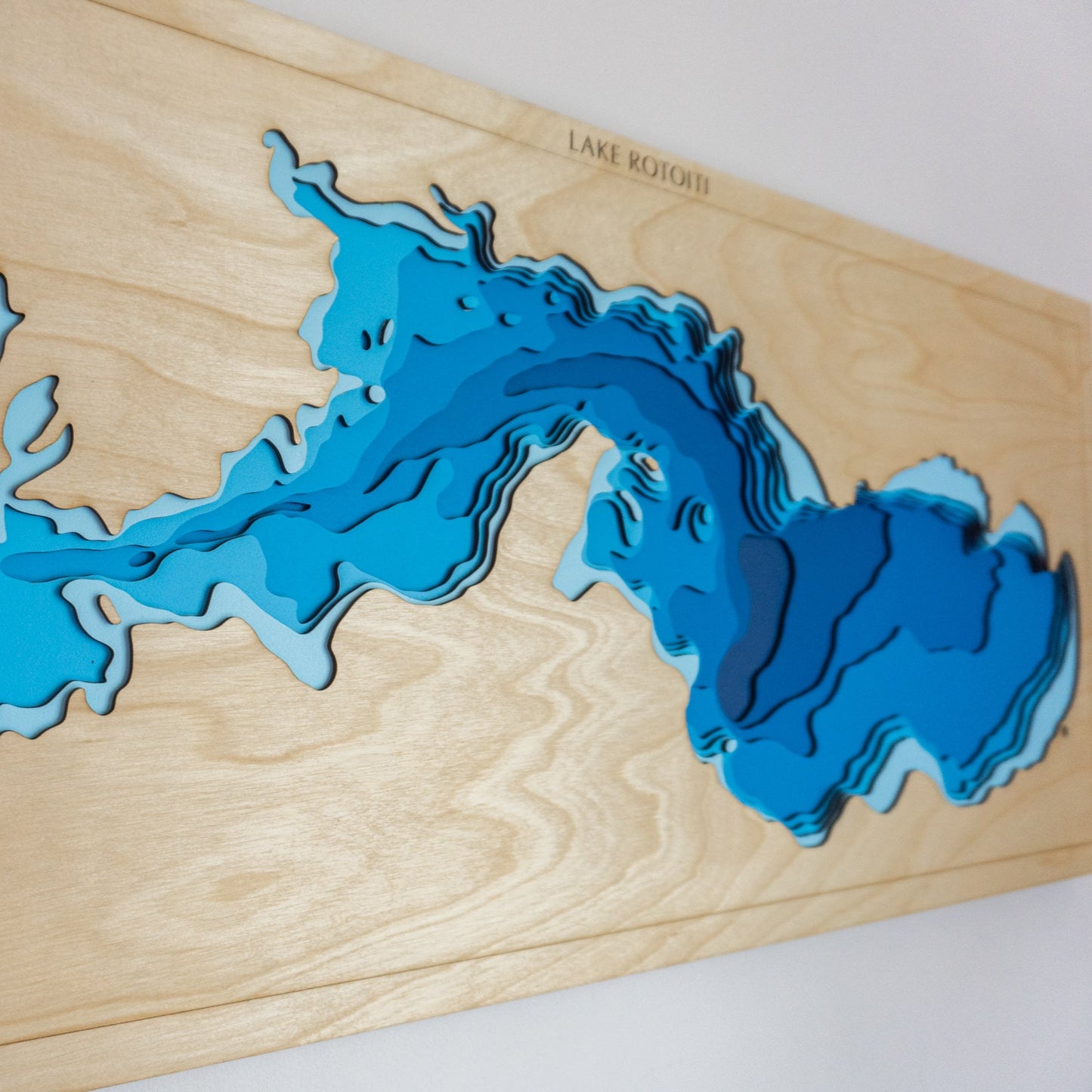 Close-up view of the Lake Rotoiti wooden map showing detailed laser-cut bathymetric layers and shoreline features.