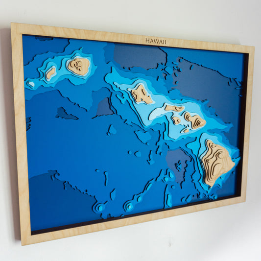 Handcrafted wooden depth map of the Hawaiian Islands, featuring laser-cut European Birch layers illustrating ocean depths from sea level to -5,000 meters, highlighting the archipelago's intricate coastline and surrounding bathymetric contours.