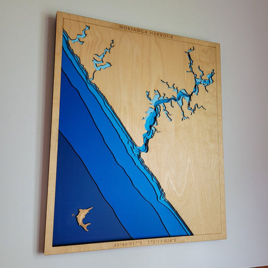 Handcrafted wooden depth map of Hokianga Harbour, Northland, New Zealand, showcasing laser-cut layers depicting the harbour's intricate coastline, estuaries, and surrounding ocean contours.