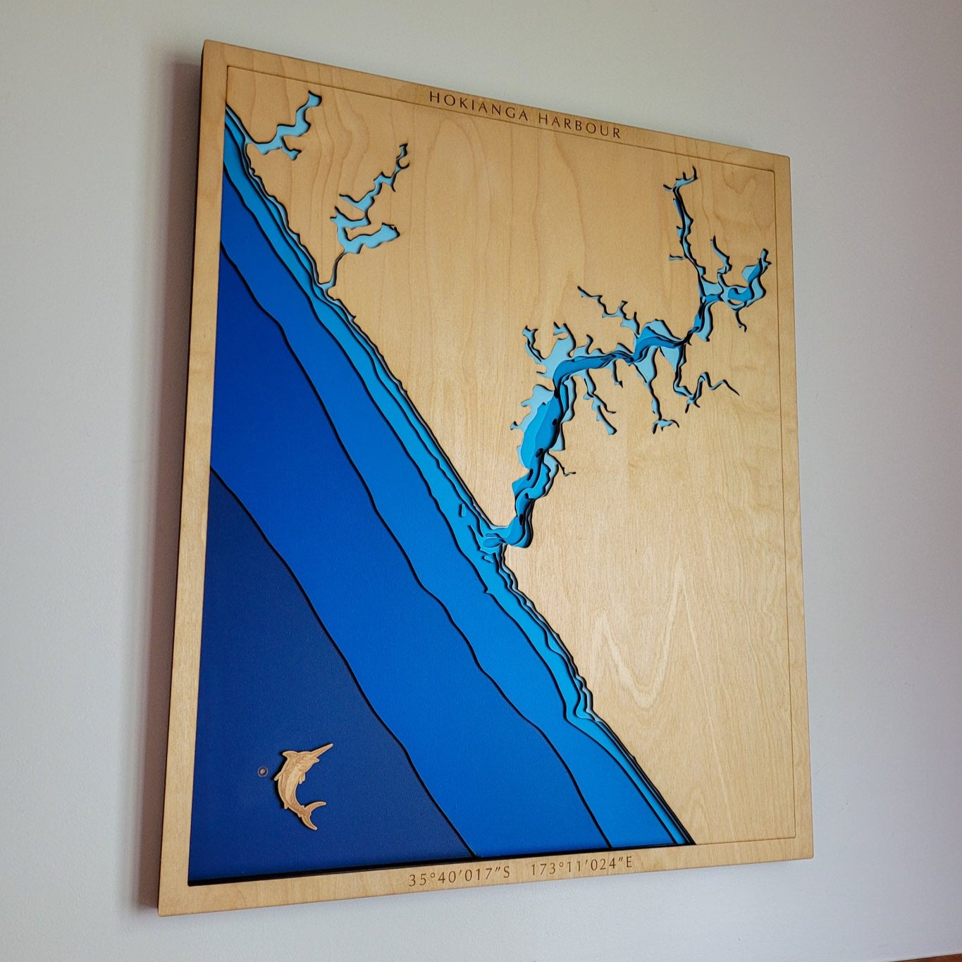 Handcrafted wooden depth map of Hokianga Harbour, Northland, New Zealand, showcasing laser-cut layers depicting the harbour's intricate coastline, estuaries, and surrounding ocean contours.