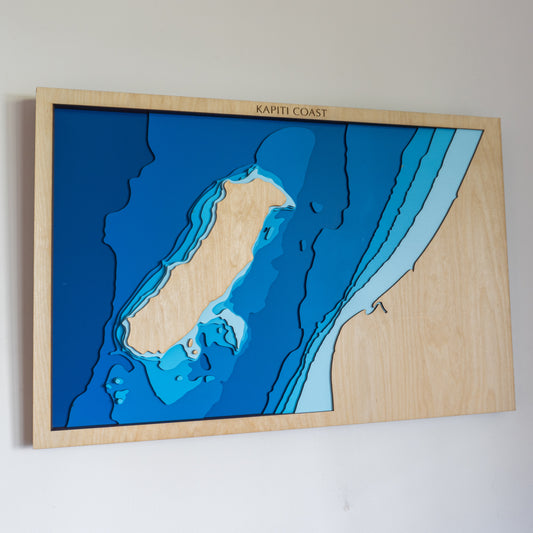 Handcrafted wooden depth map of Kāpiti Island, New Zealand, featuring laser-cut layers illustrating sea depths from sea level to -100 meters.