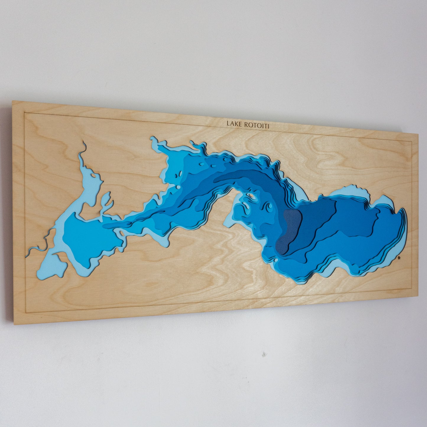 Handcrafted wooden depth map of Lake Rotoiti, Bay of Plenty, New Zealand, featuring laser-cut European Birch layers illustrating lake depths from sea level to -80 meters.