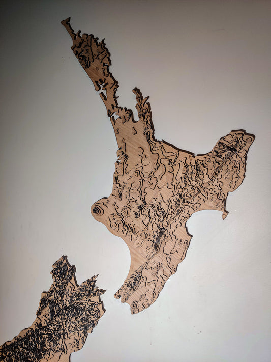Hiker planning a Great Walk in New Zealand using a topographic wall map from Tides Out Maps