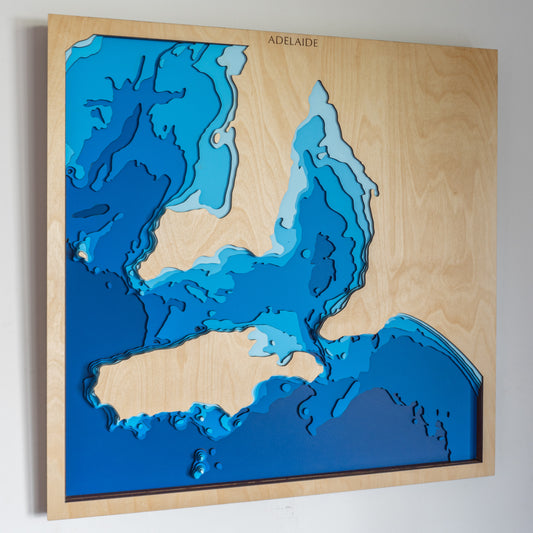 Handcrafted wooden depth map of Adelaide, featuring laser-cut layers depicting Gulf St Vincent, Glenelg beaches, Adelaide Hills, and Port Noarlunga.