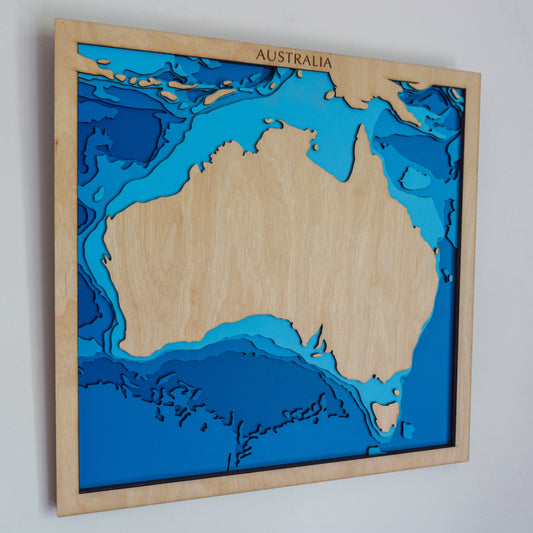 Handcrafted wooden depth map of Australia, showcasing laser-cut layers depicting the country's rugged coastlines, vast landscapes, and surrounding ocean depths.