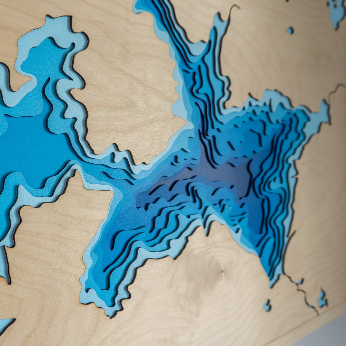Detailed close-up of the Lake Waikaremoana wooden map, highlighting the precision-cut layers and intricate detailing of the lake's shoreline and surrounding terrain.