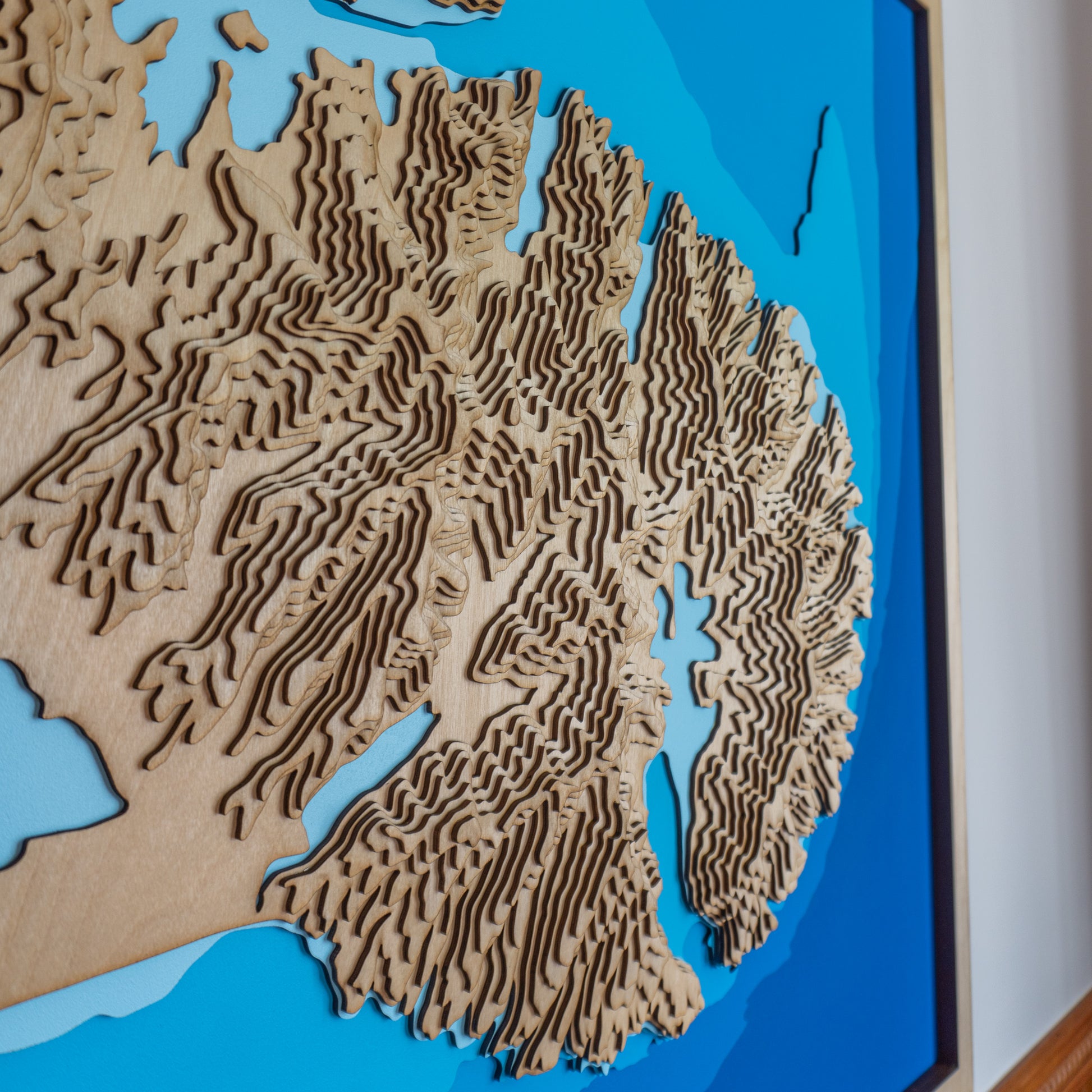 Close-up view of the Banks Peninsula XL wooden map showing detailed laser-cut bathymetric and topographic layers, emphasizing the contours of Lyttelton and Akaroa Harbours.