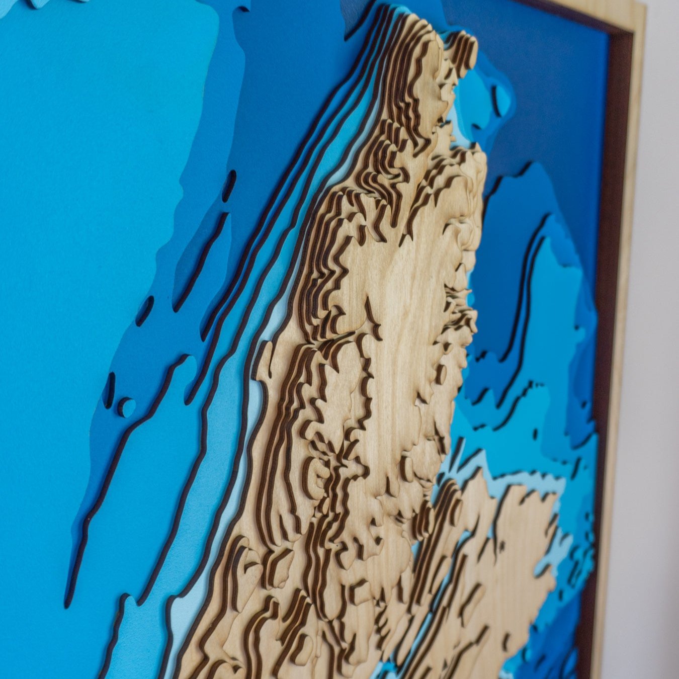 Close-up view of Cape Breton Island wooden map showing precise laser-cut bathymetric layers and detailed coastlines.