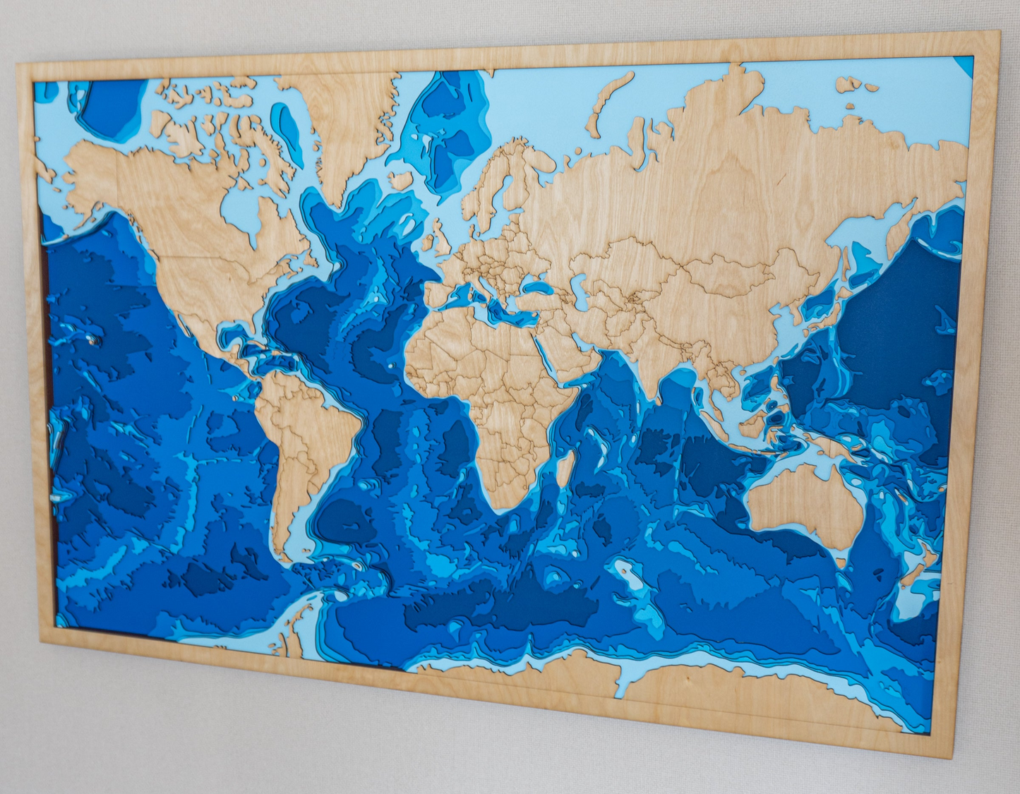 Close-up view of a custom extra-large wooden depth map showing detailed laser-cut bathymetric layers and personalized coastal features.