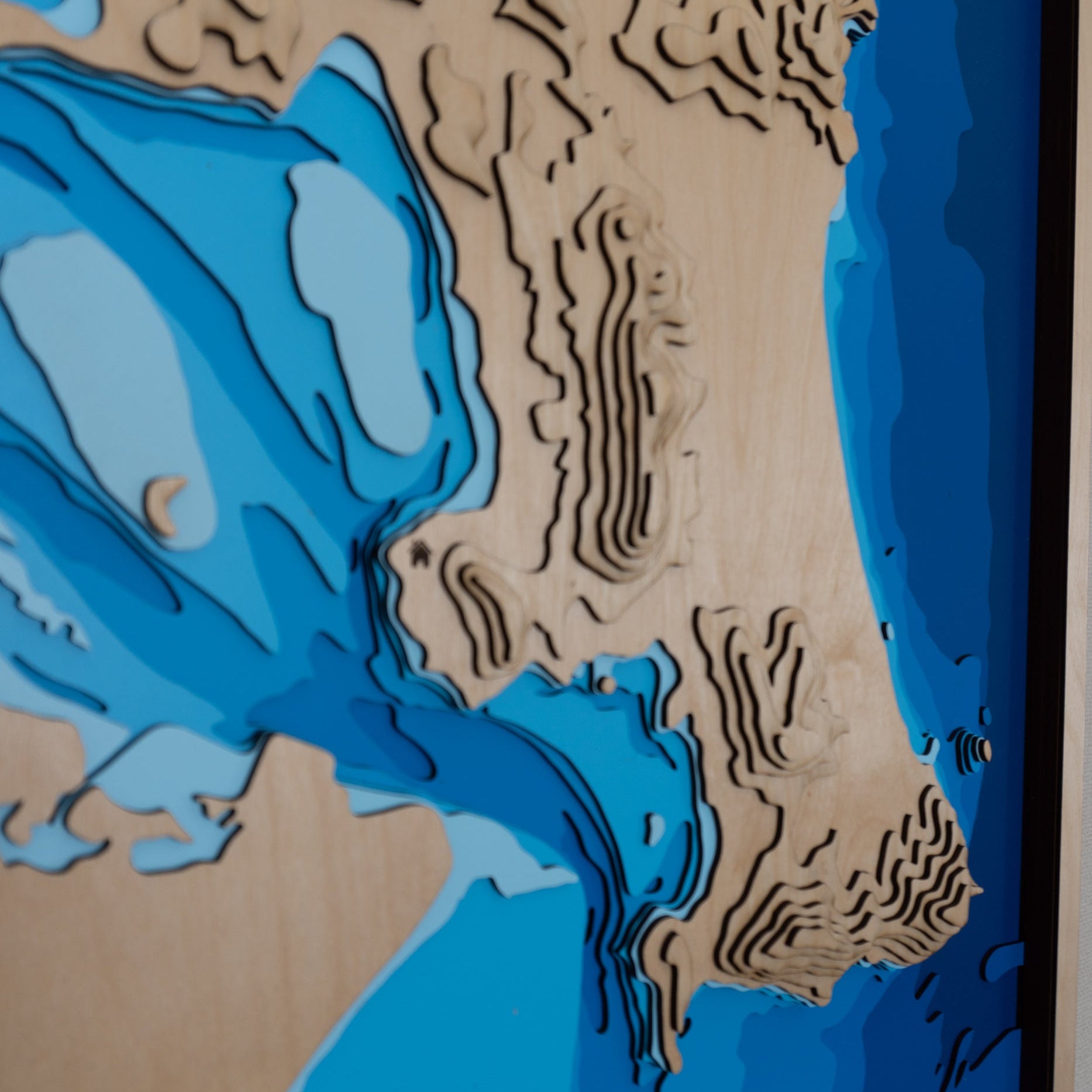 Close-up view highlighting the intricate layers and precise detailing of Whangarei Harbour's bathymetry on the wooden map.