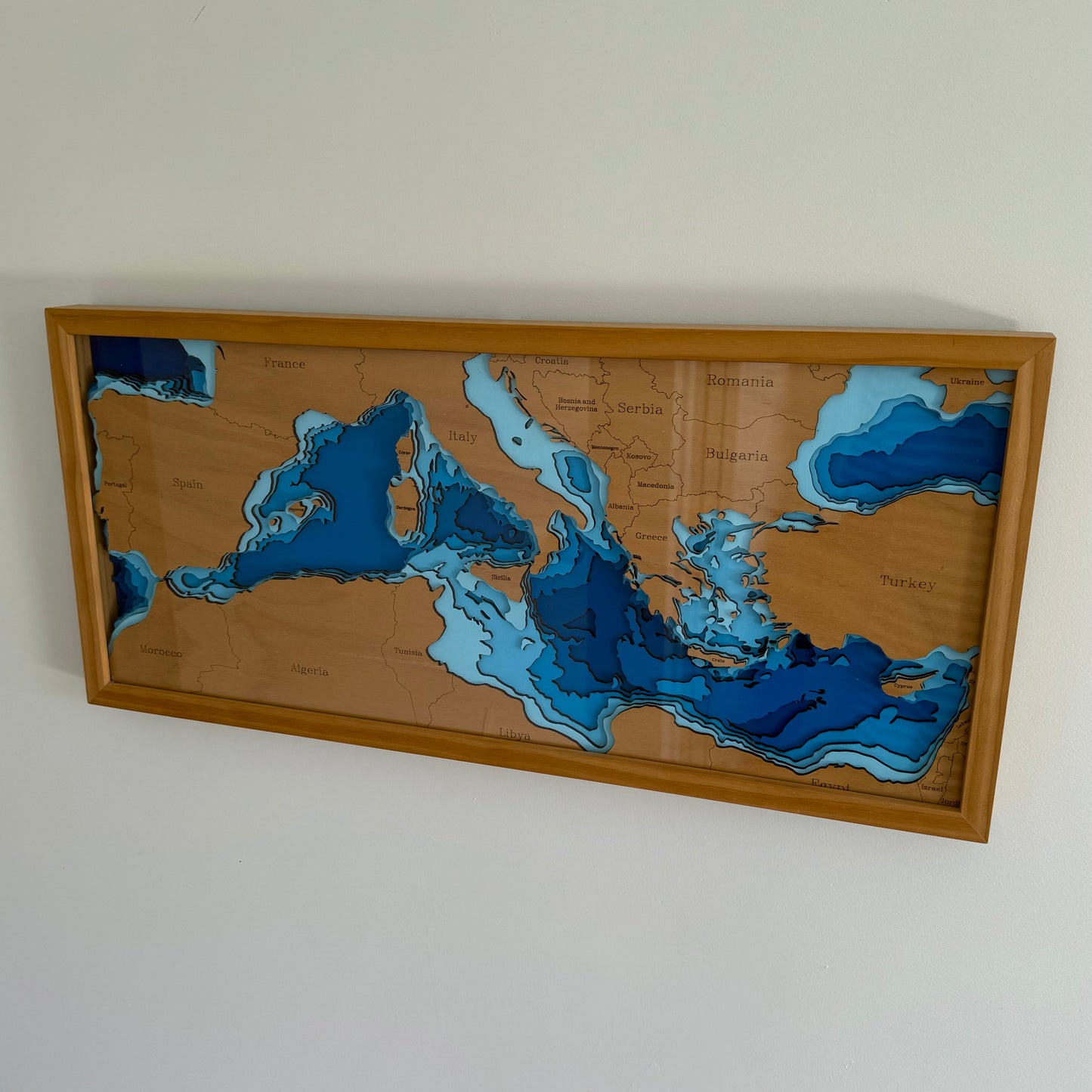 Europe - Mediterranean Sea wooden depth map displayed in a room setting, illustrating its size and aesthetic appeal as wall art.