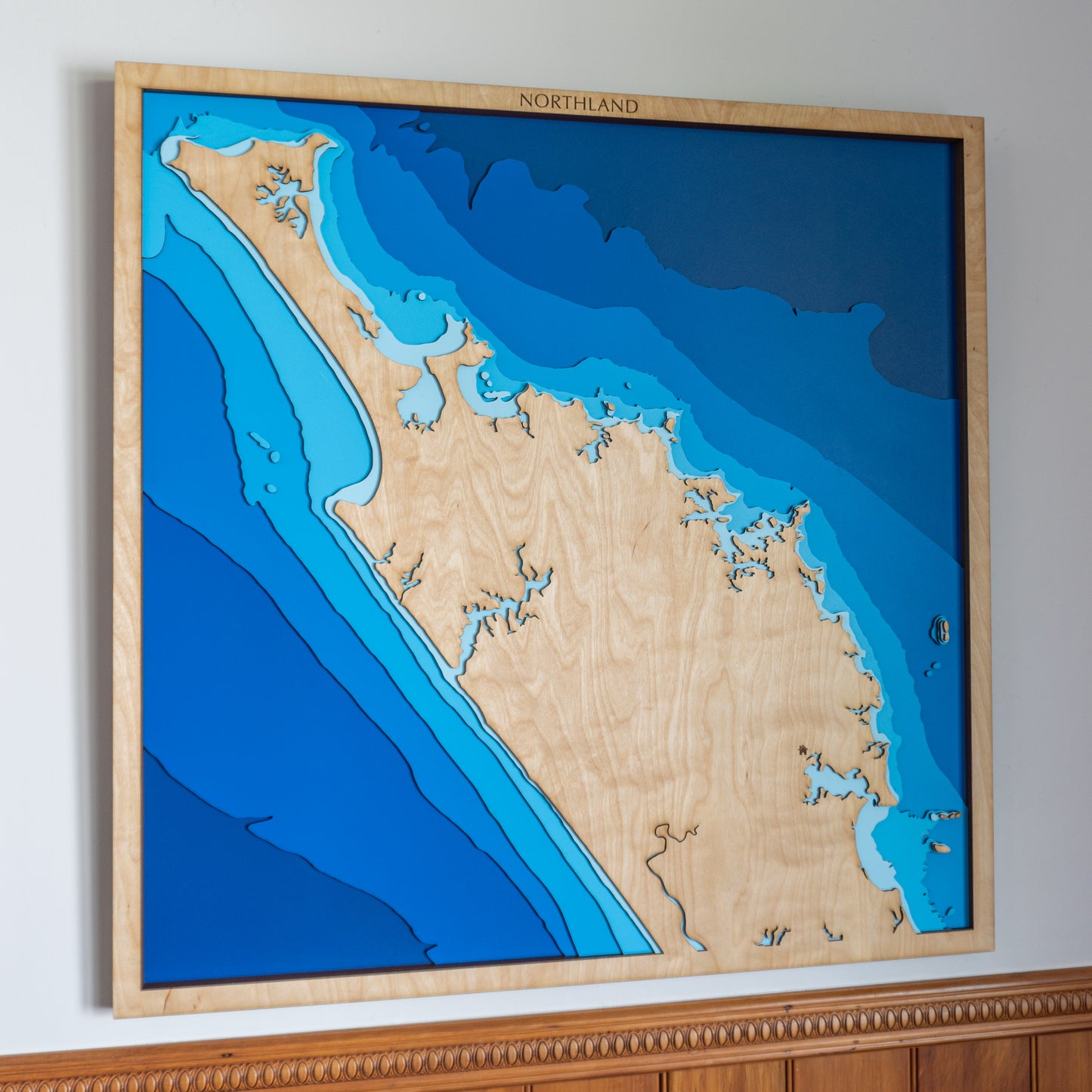 Handcrafted wooden depth map of New Zealand's Far North, showcasing laser-cut layers depicting the region's rugged coastlines, serene bays, and surrounding ocean contours.