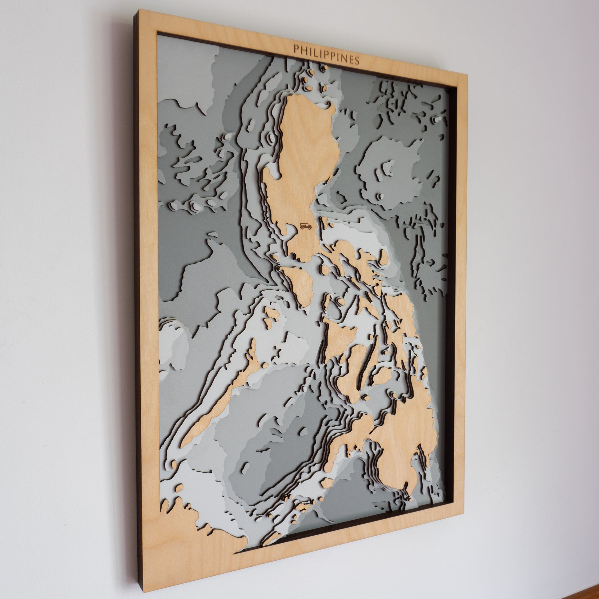 Philippines wooden depth map in grey finish, featuring layered laser-cut European Birch showcasing bathymetric detail of surrounding ocean and archipelago.