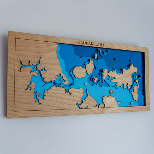 Mini wooden depth map of the Hauraki Gulf, New Zealand, featuring laser-cut layers depicting sea depths from sea level to -30 meters, highlighting Waitematā Harbour and nearby islands.