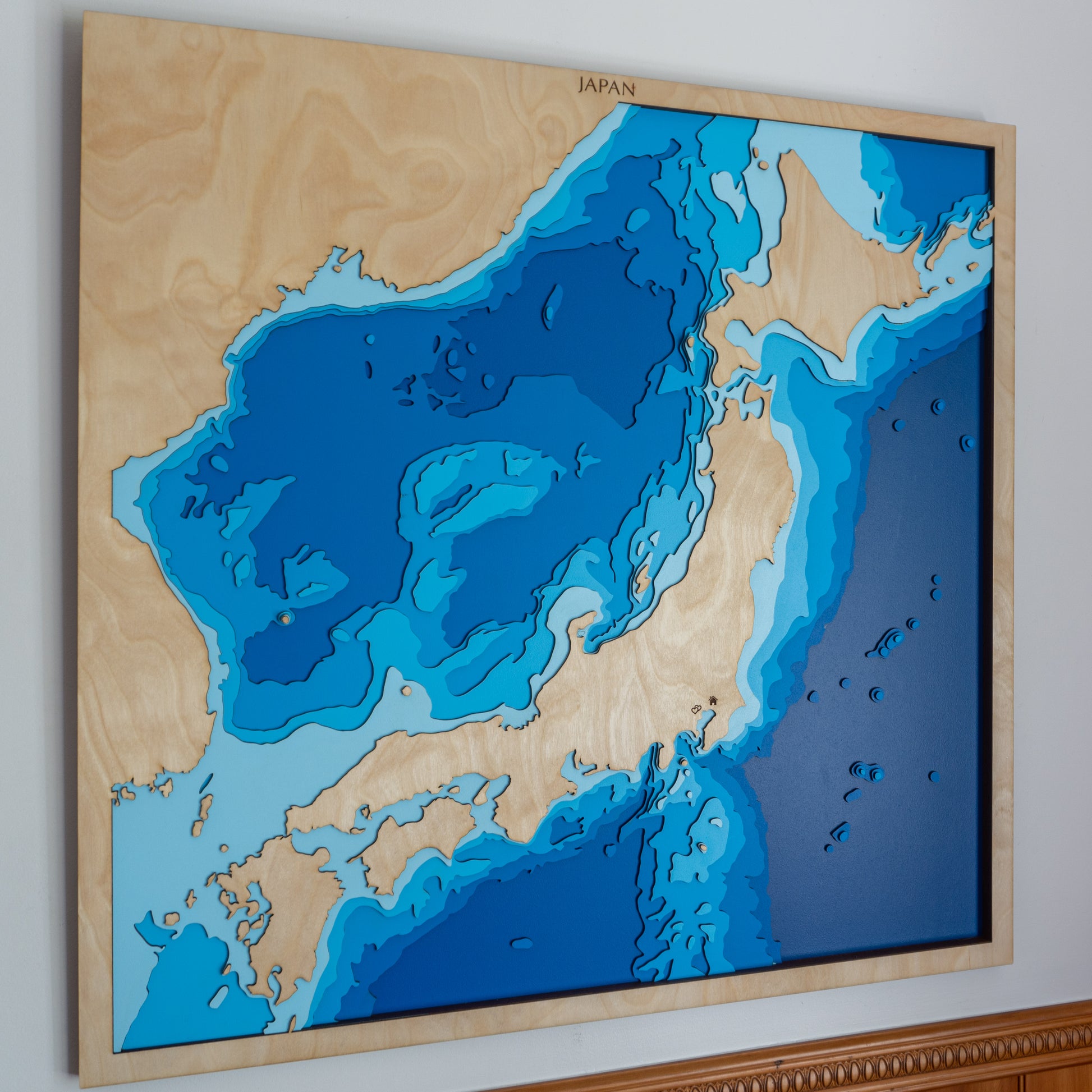 Handcrafted wooden depth map of Japan, showcasing laser-cut layers depicting the archipelago's mountainous terrain, including Mount Fuji, and surrounding ocean depths.