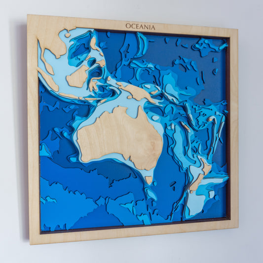 Handcrafted wooden depth map of Oceania, showcasing laser-cut layers depicting Australia's landmass, New Zealand, and the Pacific islands, highlighting the region's diverse bathymetry.