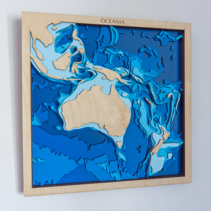 Handcrafted wooden depth map of Oceania, showcasing laser-cut layers depicting Australia's landmass, New Zealand, and the Pacific islands, highlighting the region's diverse bathymetry.