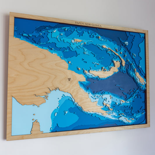 Handcrafted wooden depth map of Papua New Guinea, showcasing laser-cut layers depicting the island's mountainous terrain, surrounding seas, and intricate coastal contours.