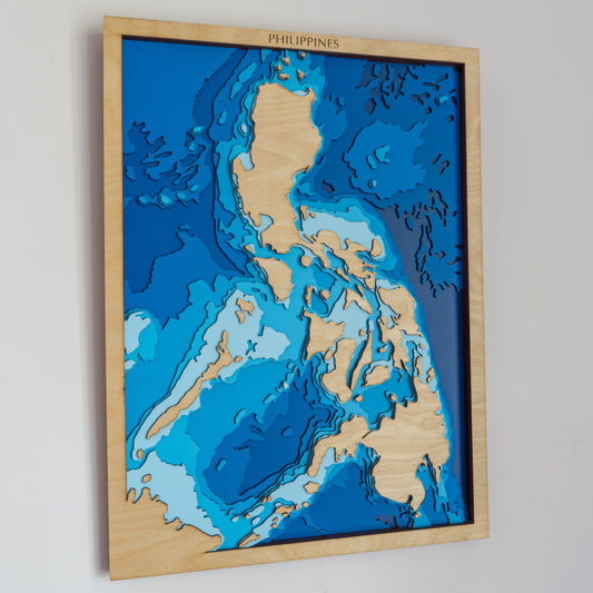 Handcrafted wooden depth map of the Philippines, featuring laser-cut layers illustrating sea depths from sea level to -7,000 meters, highlighting the archipelago's intricate coastline and surrounding oceanic trenches.