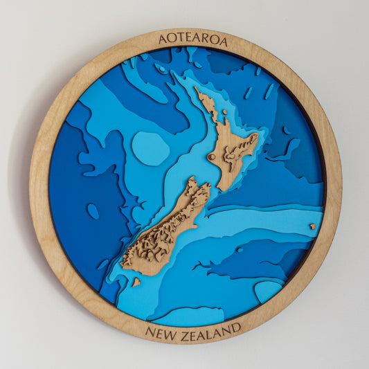 New Zealand circle wooden map with topography, the mountains raised in layers, Aotearoa engraved on the frame